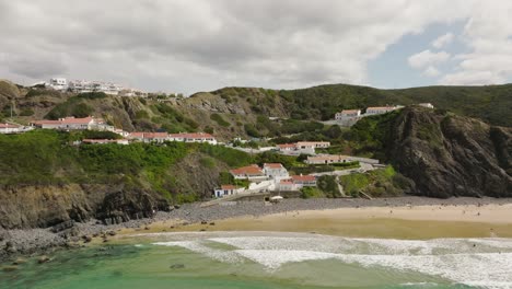 Aerial-shot-flying-over-a-crystal-clear-sea-towards-white-villas-with-orange-rooftops