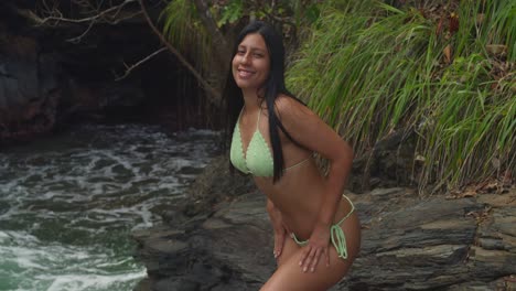 relaxed woman in a bikini on a trinidad cliff overlooking the turquoise beach