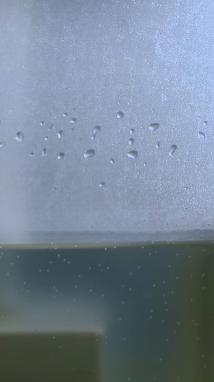 CU shot: side of modern air ionizer full of clean water emitting steam to humidify air and neutralize bacteria extreme closeup