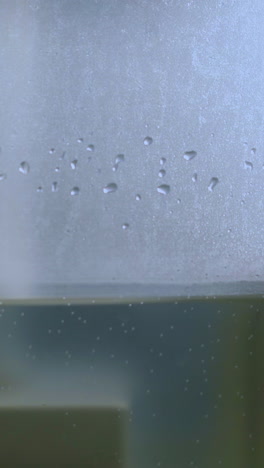 cu shot: side of modern air ionizer full of clean water emitting steam to humidify air and neutralize bacteria extreme closeup