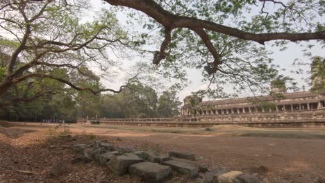 Wide-pan-shot-showing-the-large-temple-buildings-in-Angkor-Wat-in-Cambodia,-bright-sunny-daylight