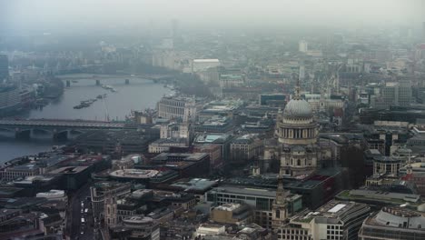 aerial view showing a cityscape of london; with st pauls and the river thames in fog.
