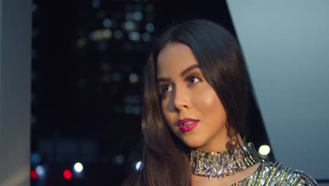 Young-woman-facial-close-up-at-night-with-city-light-of-the-Caribbean-city-port-of-Spain,-Trinidad-in-the-background