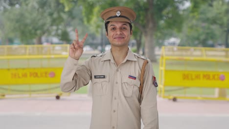 Glücklicher-Indischer-Polizist,-Der-Siegeszeichen-Zeigt
