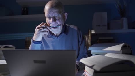 Close-up-of-senior-researcher-man-reading-book,-doing-research-in-library.