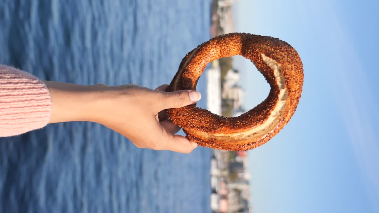 simit turco sostenido en la mano por una mujer