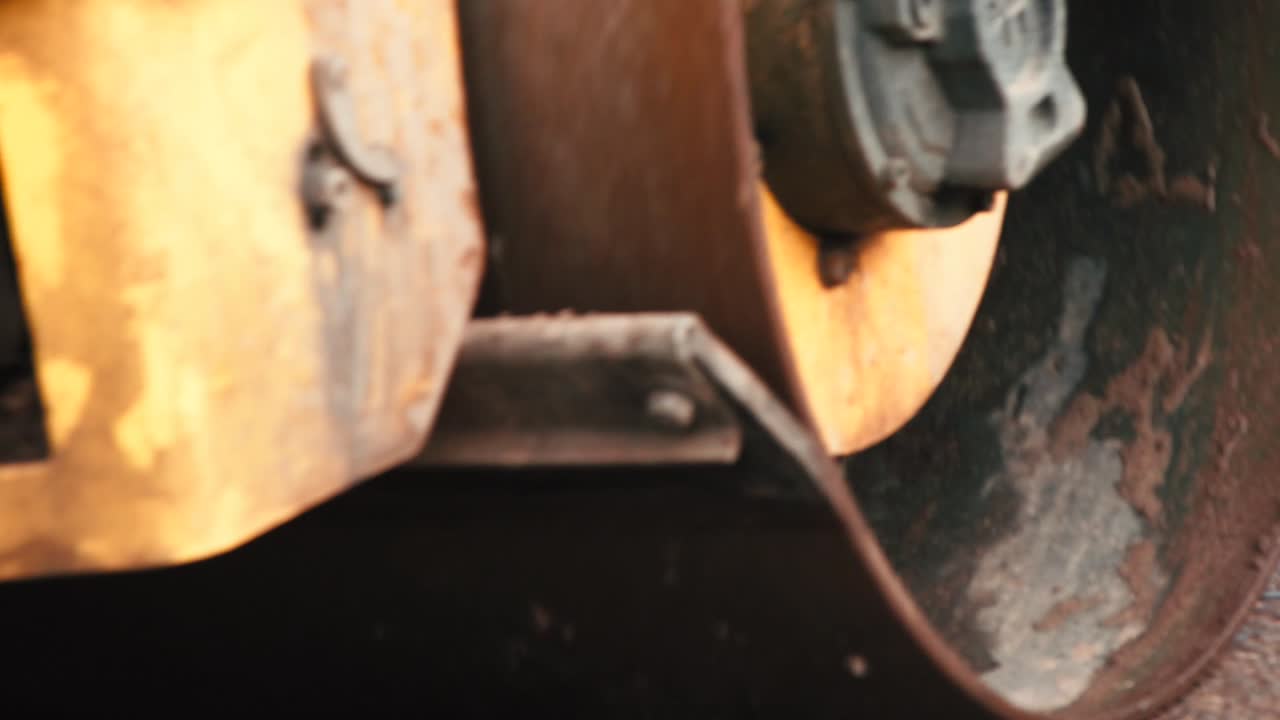 무거운 압착기가 뜨겁고 김이 나는 아스팔트 위로 운전하여 압축합니다.