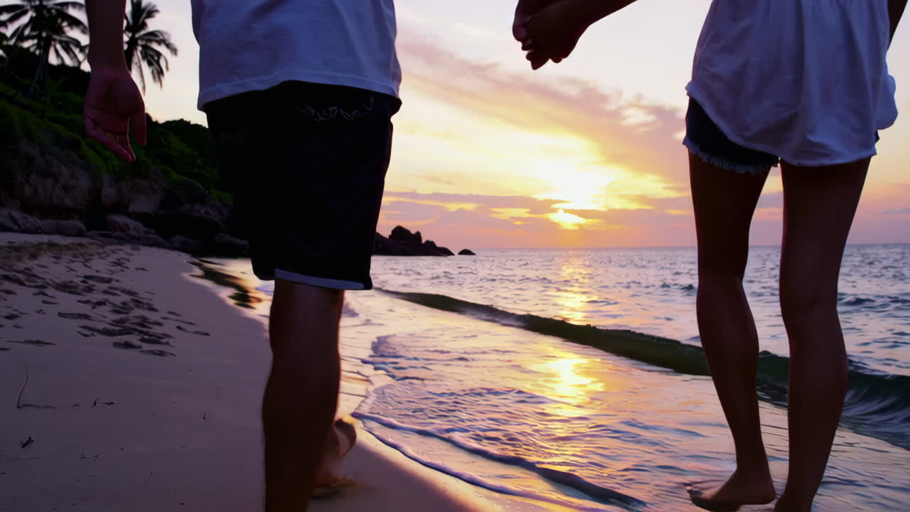 pareja caminando por la playa al atardecer