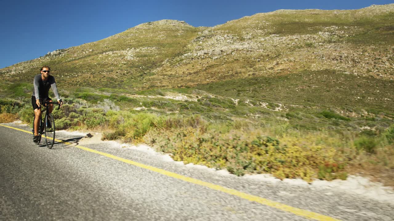 시골 도로 에서 자전거 를 타고 있는 트라이애슬레트 남자