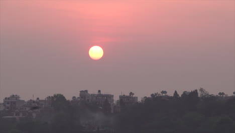 the morning sun rising over the rooftops of the houses in kathmandu