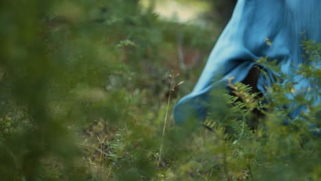 close up of a woman with blue dress running in the forest, mysterious moody shot