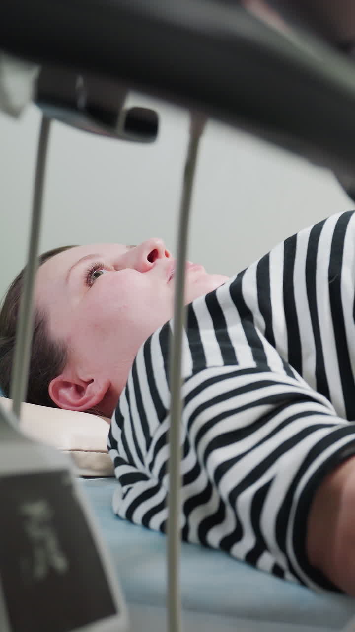 caucasian woman lying on MRI table in striped shirt, supine inside scanner with tense expression close view through machine rails, clinical radiology room with sterile lighting and monitor