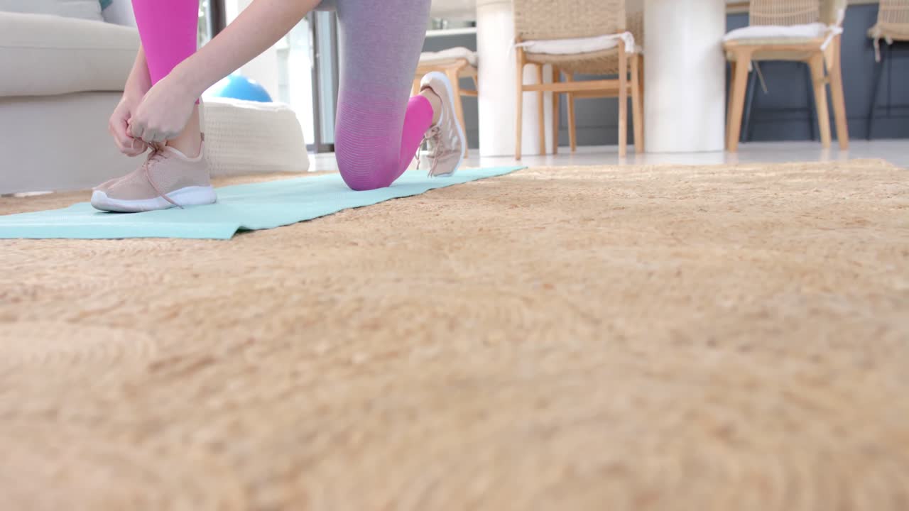 백인 여성 이 슬로우 모션 으로 집 에서 매트 에 신발 을  ⁇ 고 있다