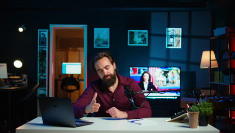 joyful content creator sitting at table talking in microphone