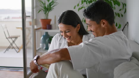 Excited-spouses-reading-sofa-closeup.-Laughing-couple-speaking-in-luxury-house