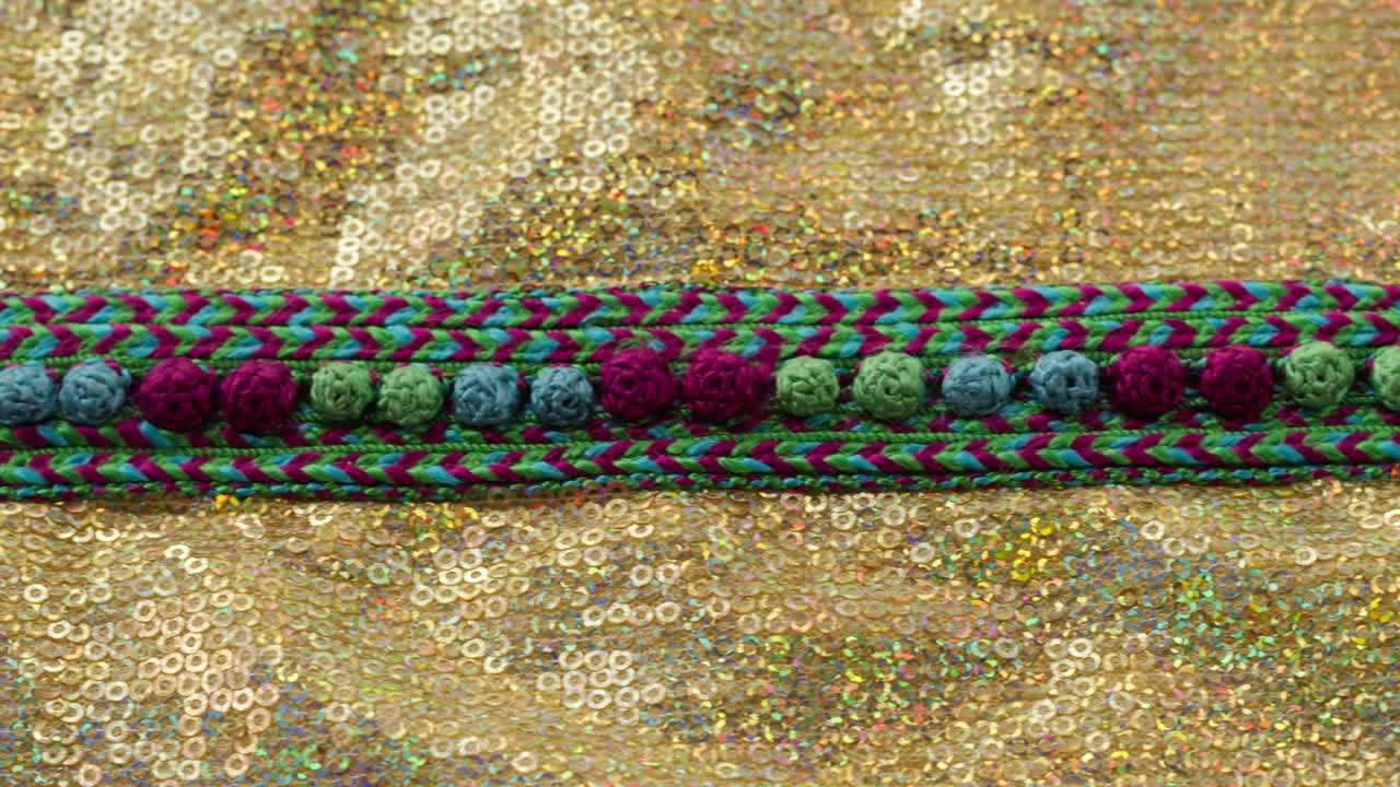 patrón de color tejido en tela brillante dorada con pañuelos de primer plano. confección de ropa festiva. fondo brillante dorado. concepto de coser vestido de año nuevo