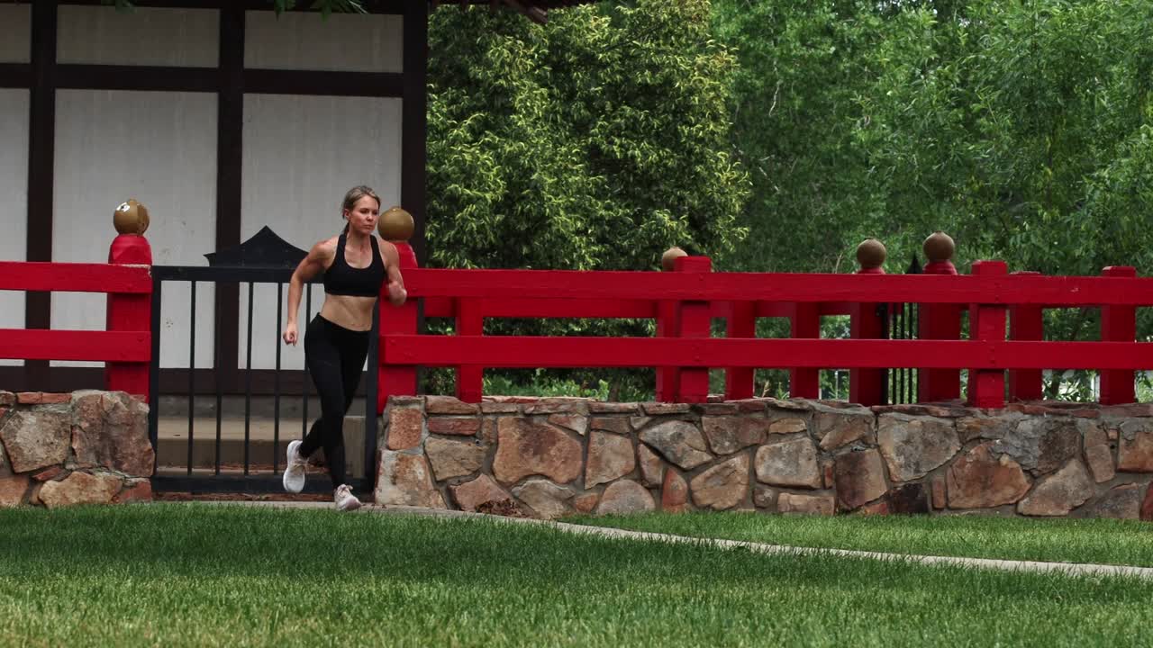 An athletic woman running at a quick pace into frame shot on gimbal