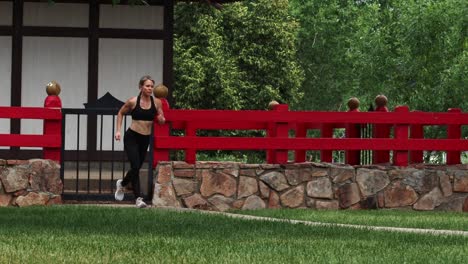an athletic woman running at a quick pace into frame shot on gimbal