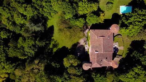 Toma-De-Arriba-Hacia-Abajo-Con-Drone:-Castillo-Rodeado-De-Bosque-Provenzal,-Piscina-Y-Techo