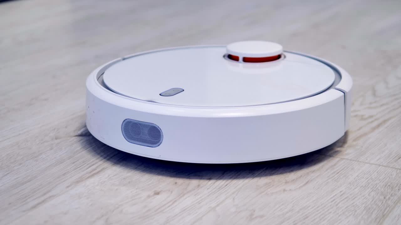 A robotic vacuum cleaner works on a laminate flooring.