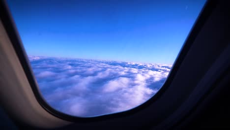 beautiful view out of airplane window of the tops of clouds