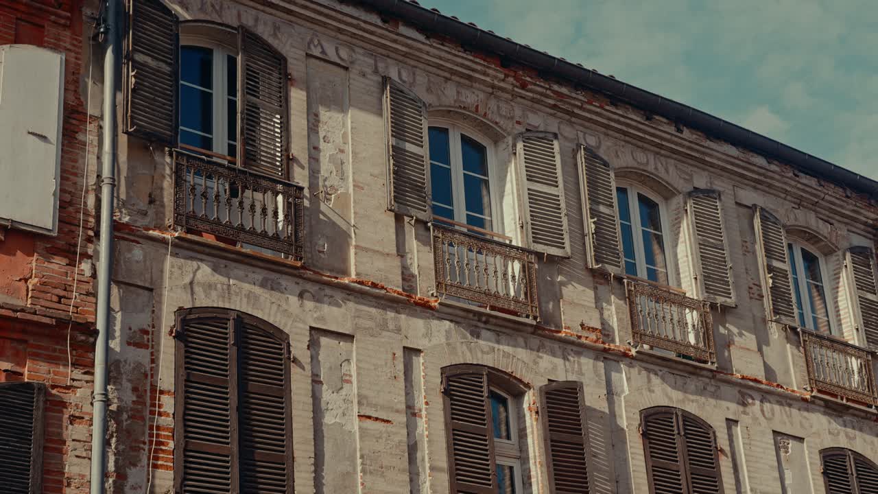 Facciata di Antico Edificio Europeo con Finestre e Persiane in Legno