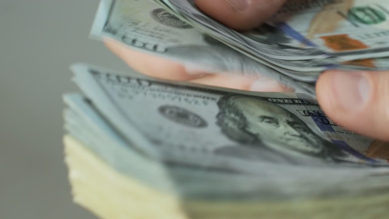 las manos de los hombres cuentan rápidamente los billetes. el hombre de negocios cuenta los dólares en las manos.
