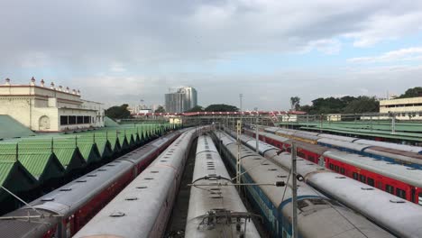 many trains are lined up next to each other at train station in india