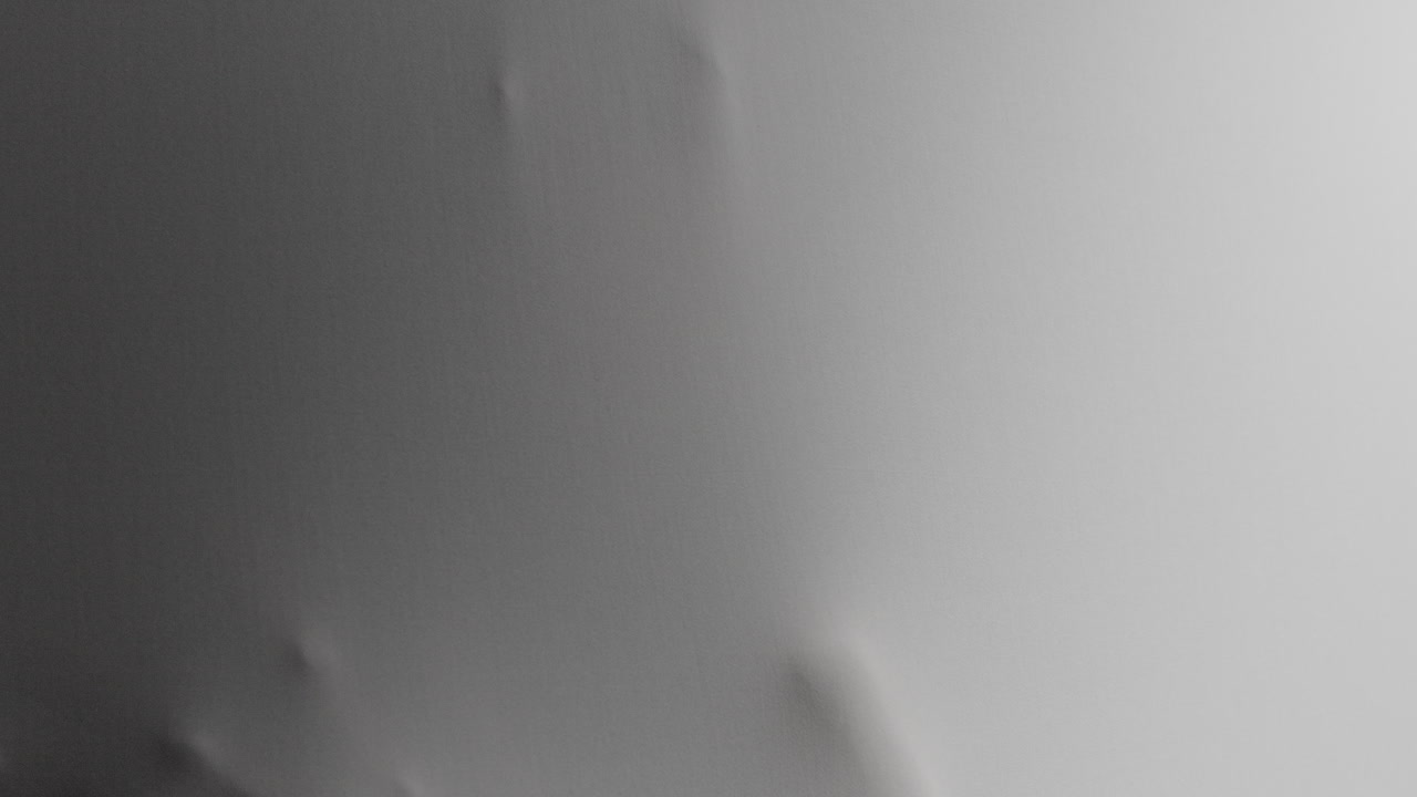 A scary face and hands appear from the white surface