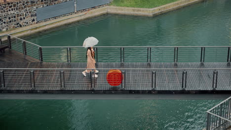Walking,-morning-and-women-on-bridge-during-rain
