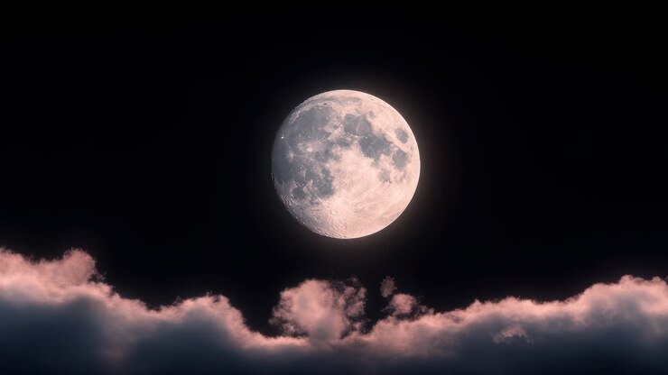 Uma lua cheia brilha intensamente contra um céu escuro, com nuvens abaixo