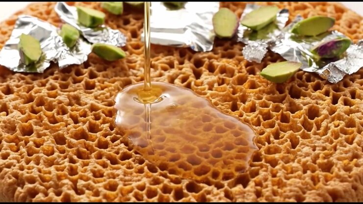 Honey Pouring Over Traditional Indian Ghevar Dessert