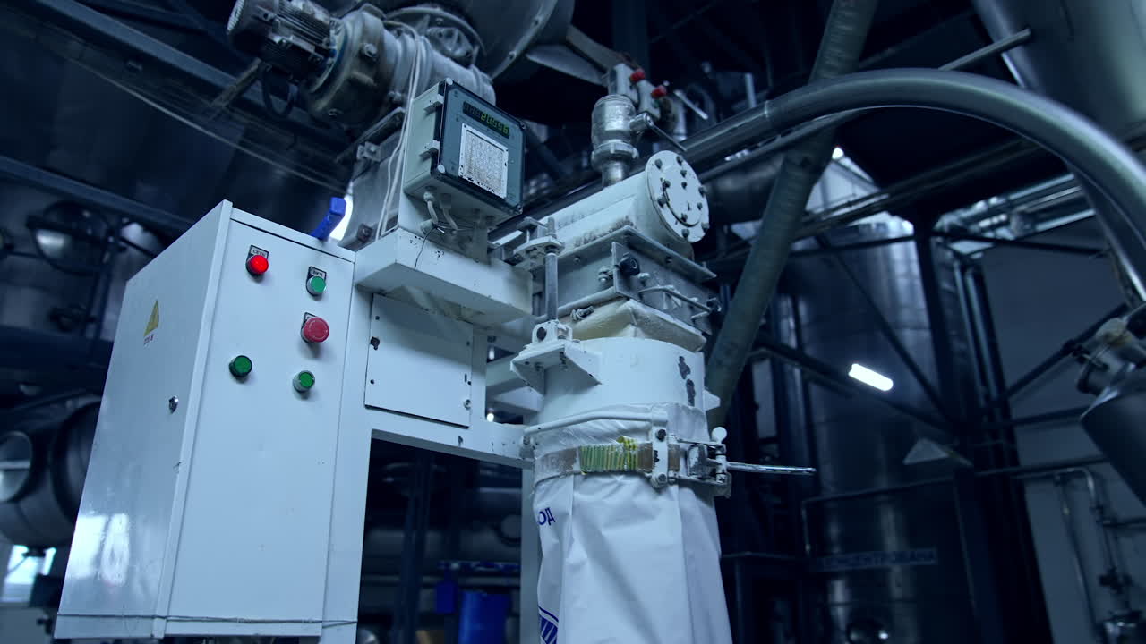 Controller box with buttons and timer as part of the equipment at modern industrial production. Big engine attached to the controller box, ready to pump dairy product. Close view with gradual distancing.