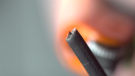 llama del encendedor macro acercándose al incienso encendido