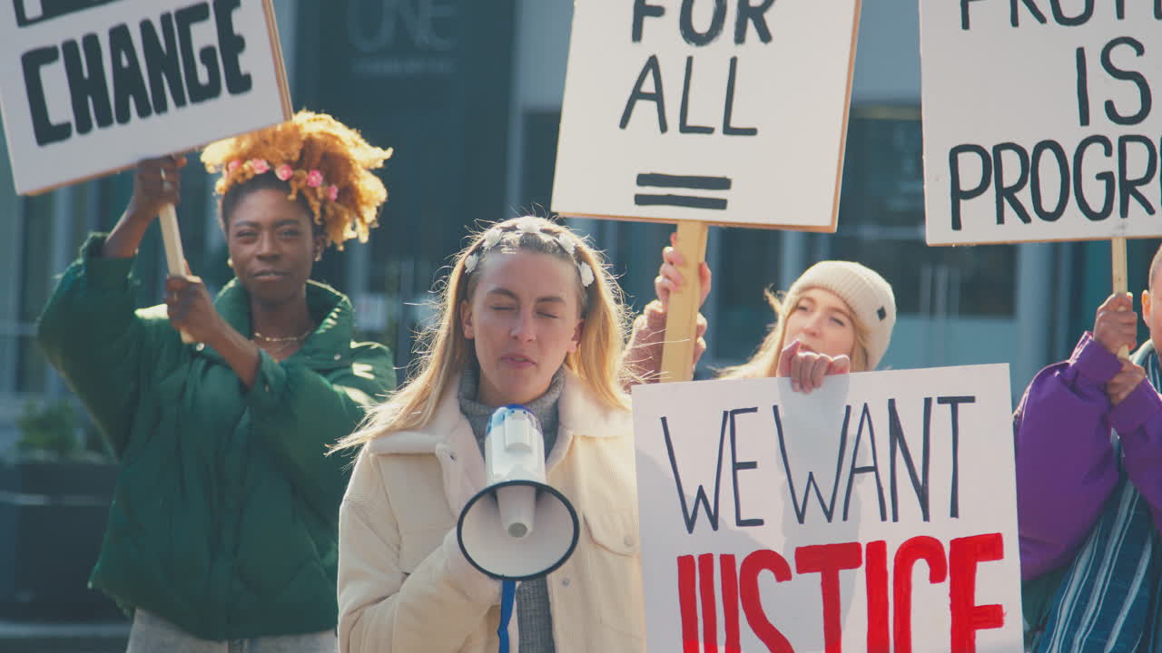 женщины-протестующие с плакатами и мегафоном на демонстрации "черные жизни важны"