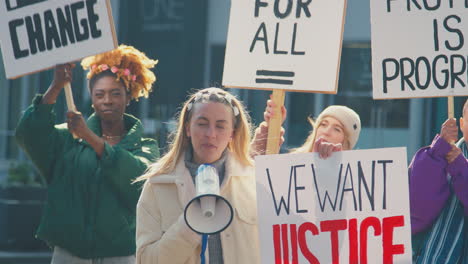 female protestors with placards and megaphone on black lives matter demonstration march