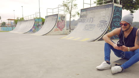 young boy using cell phone on a skate park