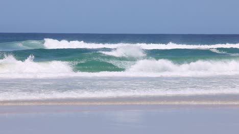 sequential view of ocean waves hitting the beach