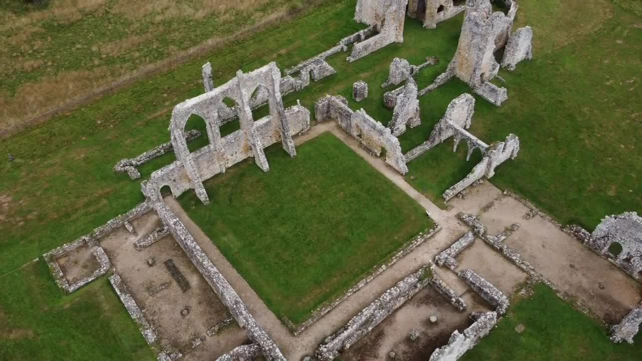 An epic drone shot soaring high above the stunning ruins of Bayham Old Abbey, revealing the full scale of its historic architecture and serene countryside setting