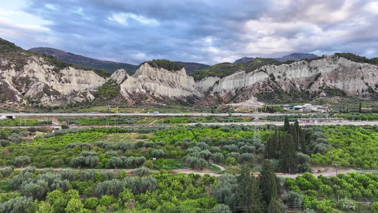 Jagged white cliffs and vibrant greenery off the coast of Corinth in Greece DOLLY FORWARD