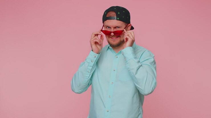 Playful happy man wearing sunglasses blinking eye looking at camera with smile winking flirting