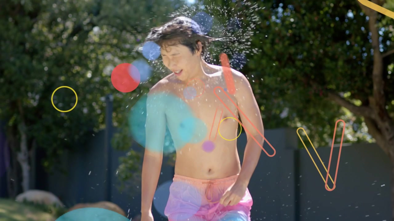 Hombre asiático en bañador rosa emergiendo de la piscina del jardín después de nadar, sacudiendo el agua mientras las superposiciones se mueven.