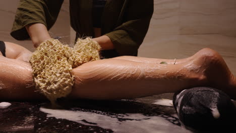 woman receiving a body scrub at a spa