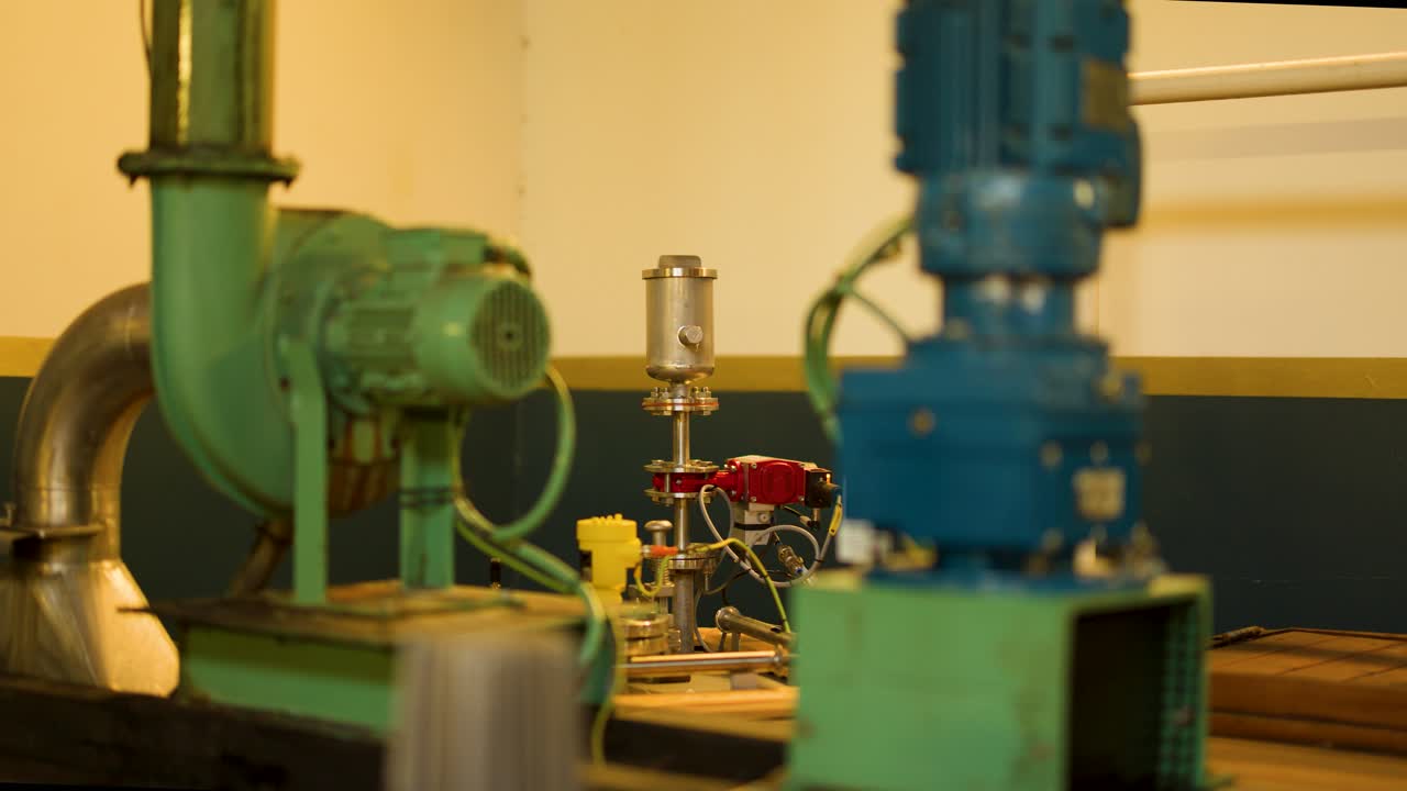 Electric motor operates on machinery in warmly lit Scottish Highlands industrial facility, smooth camera pan