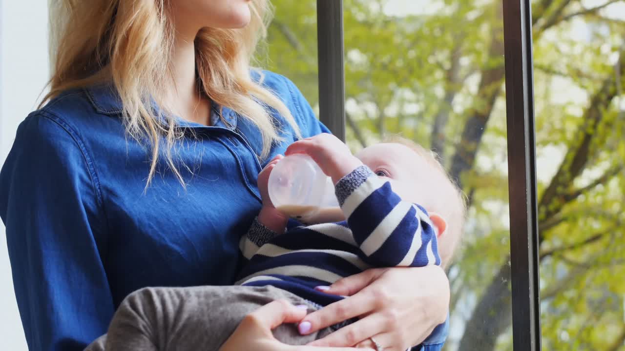 madre alimentando a su bebé 4k