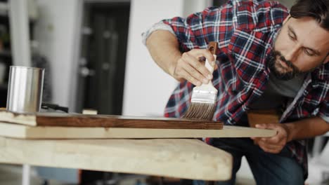 video de un hombre pintando tablas con un pincel