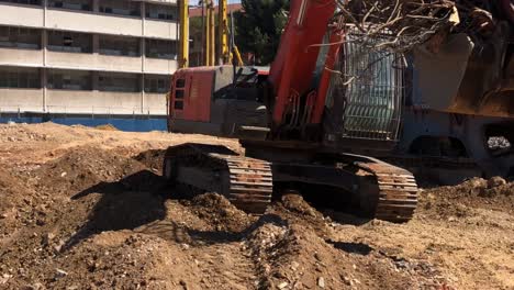 wide shot of hitachi zaxis excavators working on a construction site in cape town, south africa. nedium wide shot of transport of metal scrap on the dipper.