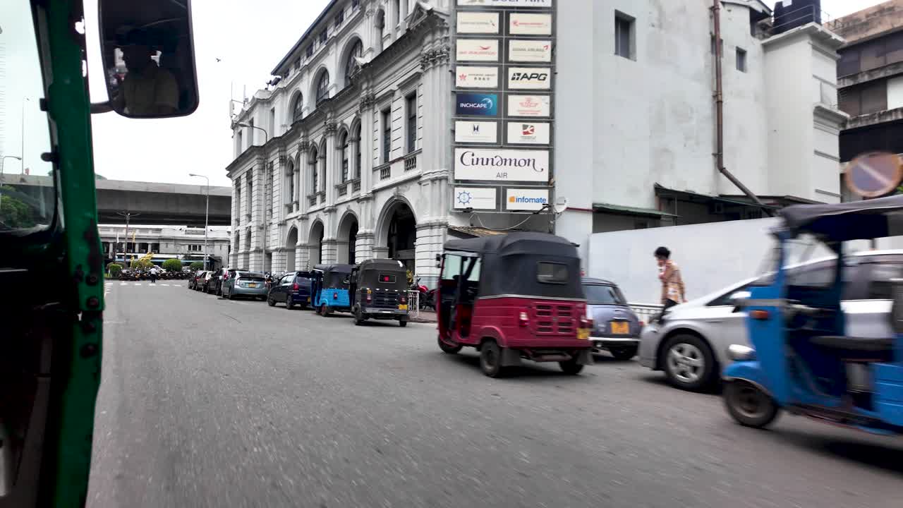 Experience a vibrant POV journey in Colombo, Sri Lanka, from a tuk tuk. The bustling street scene showcases urban architecture, traffic, and local life.