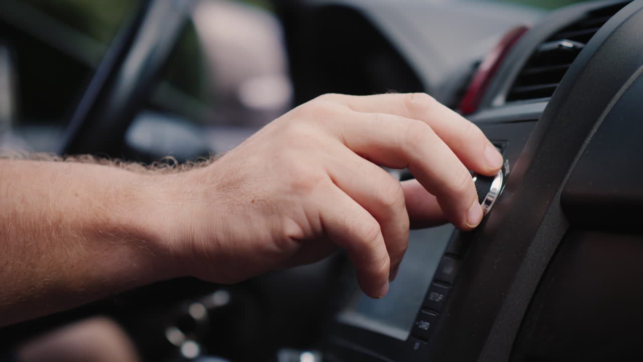 남성 손은 자동차 라디오 클로즈업 샷의 튜닝을 조정합니다.