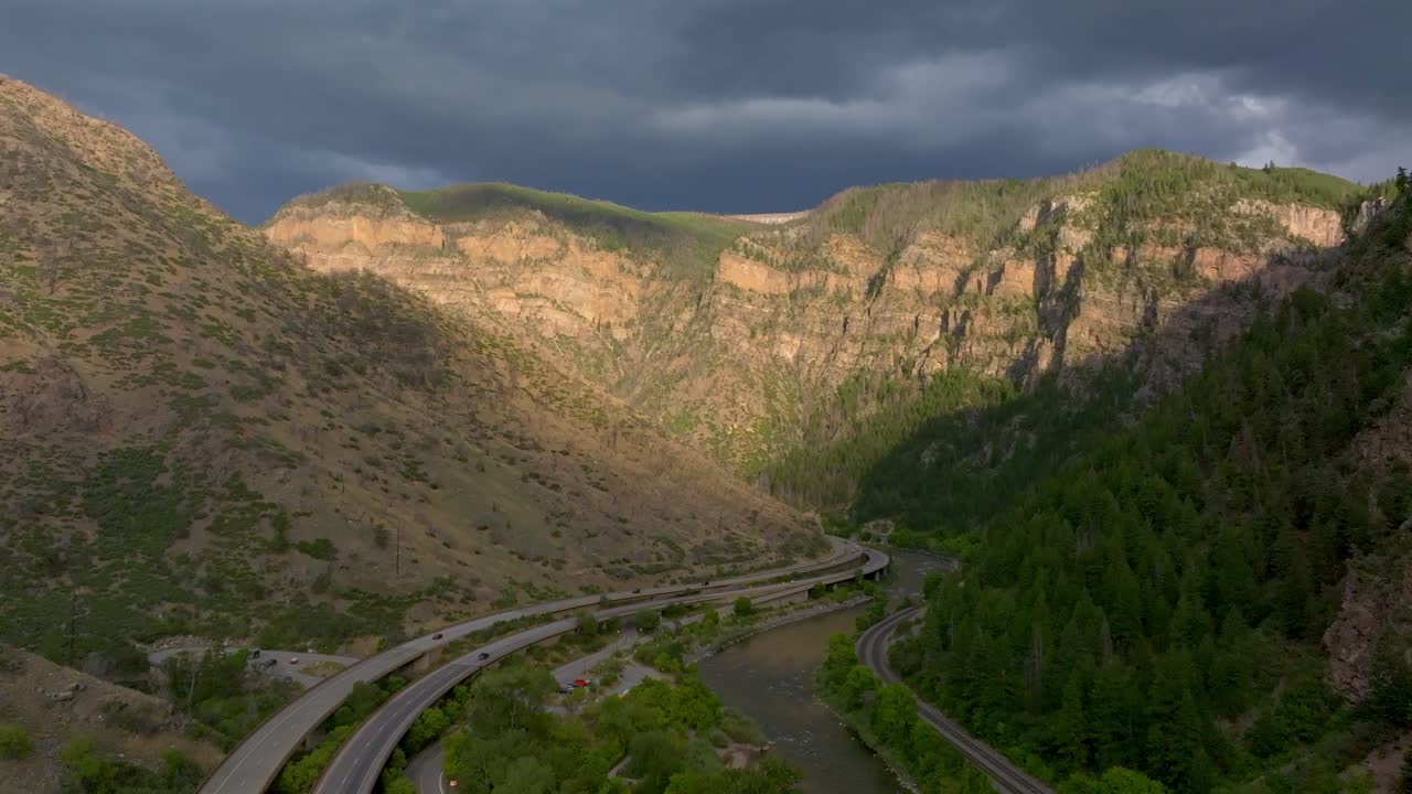 Glenwood Springs, ripresa aerea con drone estiva, Glenwood Canyon Scenic Drive, traffico auto i70 ovest est, fiume Colorado, sole, scogliera, pomeriggio, tramonto, buio, pioggia, temporale, nuvoloso, movimento in avanti e verso l'alto.